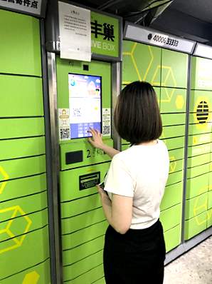 ビル1階のスマート宅配ロッカーを利用して荷物を受け取るトランスコスモスチャイナの孫さん