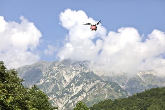 楽天は山岳エリアでのドローンを活用した物資配送飛行の実証実験を実施、長野県白馬村の白馬岳登山口にある日山岳宿舎「白馬山荘」（標高2832メートル）への物資輸送に成功